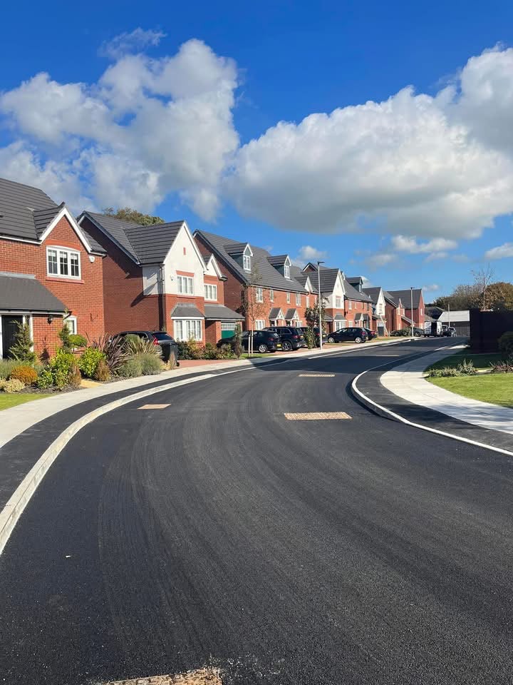 Newly surfaced road and footpaths through a housing development.